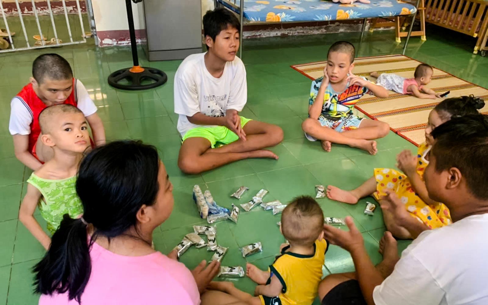 a group of children with developmental disabilities sit on the floor together for an activity in Vietnam