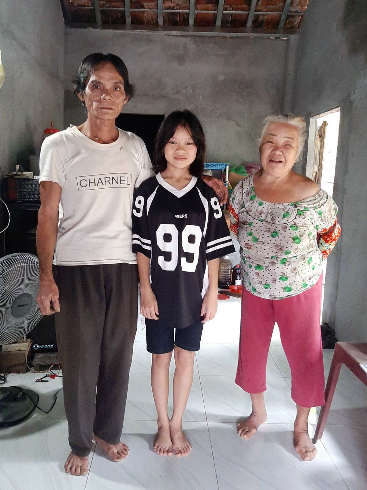 Thuy smiles with her grandparents — thankful for your educational support in Vietnam