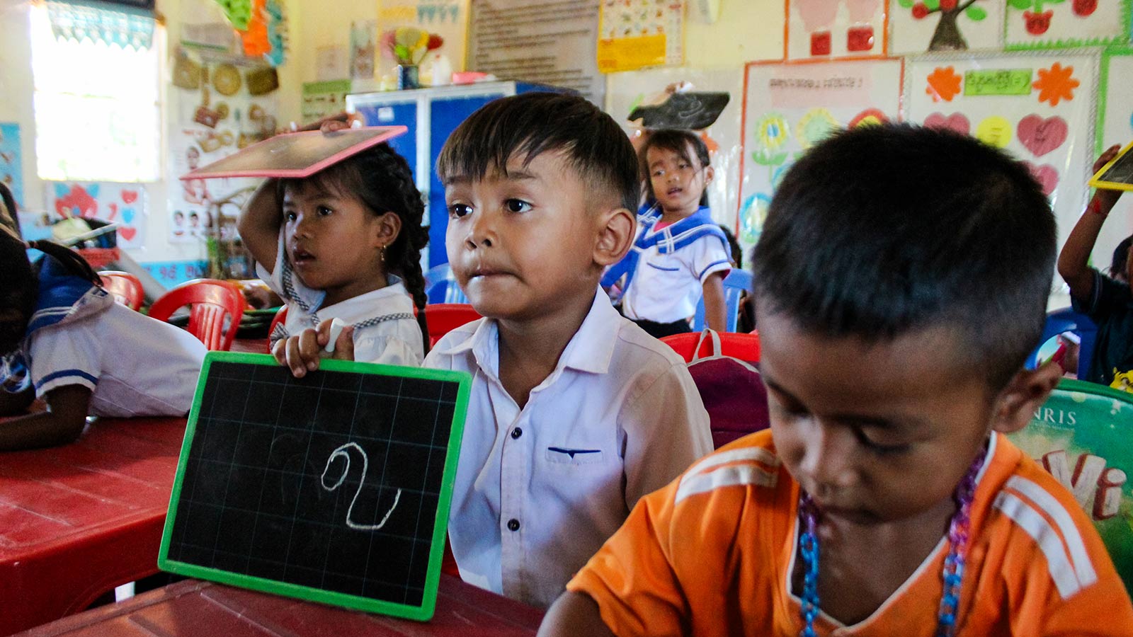 a child learns in the classroom thanks to school lunches provided by donors