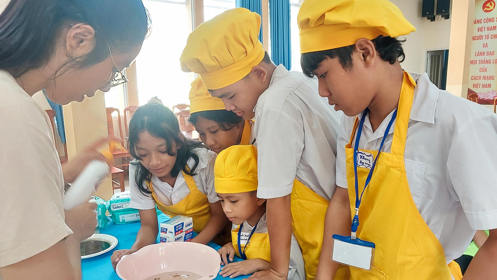 children in vietnam peer into a bowl during a Roots to Grow training session