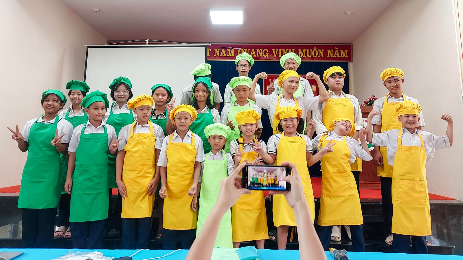 children wear aprons and chef hats in vietnam during a Roots to Grow nutrition training