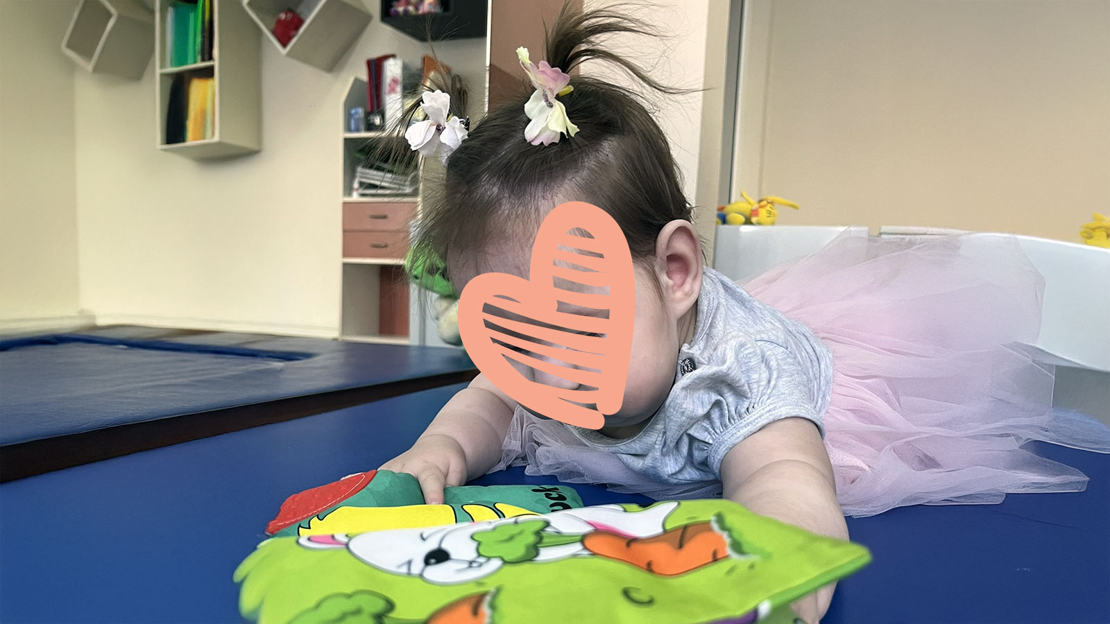 A waiting child in need of an adoptive family plays with a book.