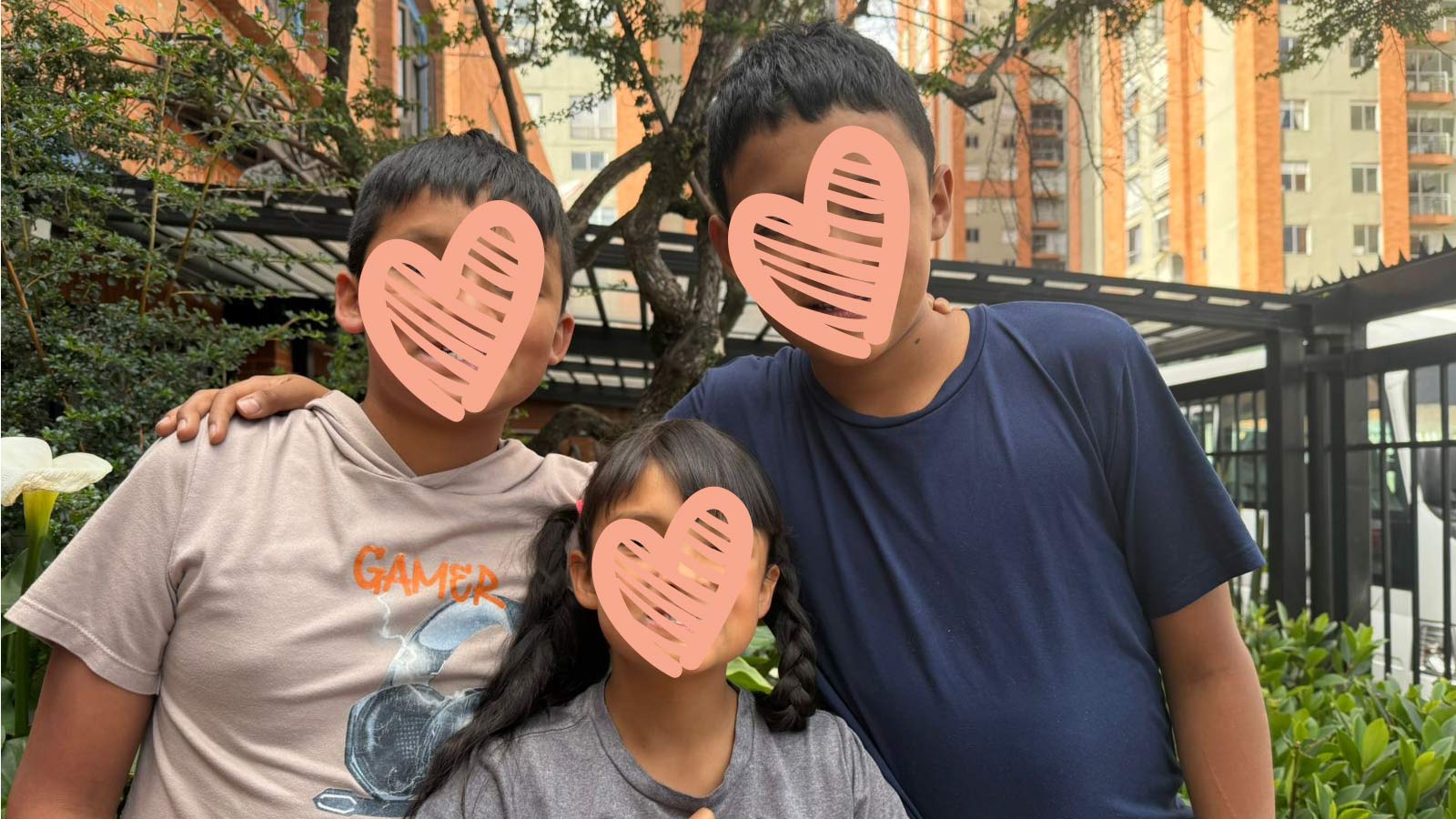 three siblings embrace for a photo, waiting to be adopted