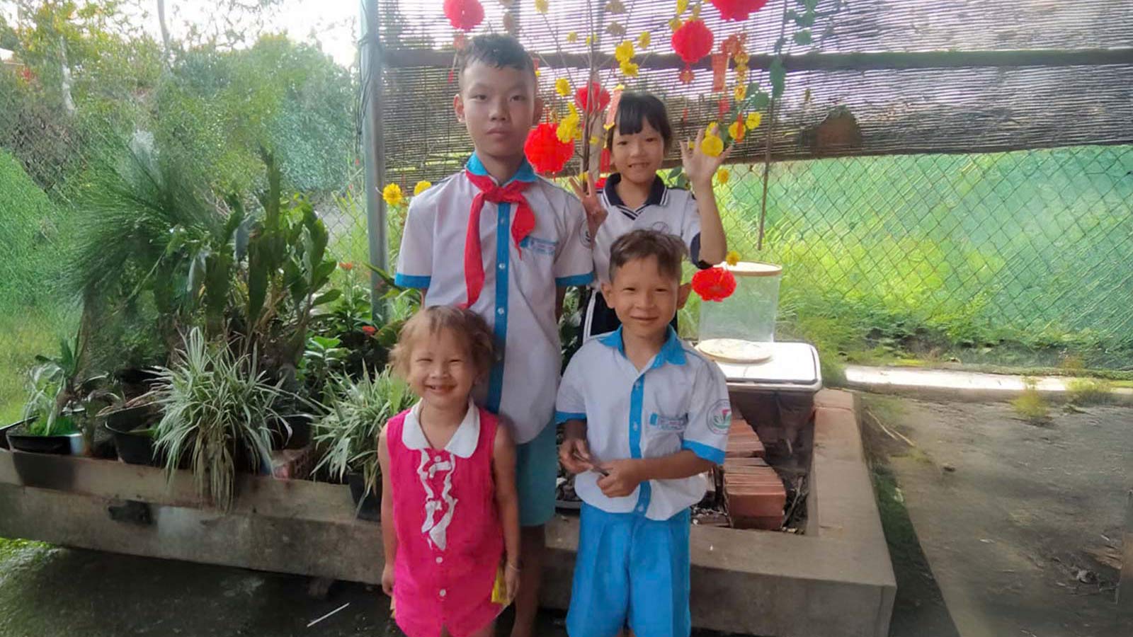 a family in vietnam stands with happy smiles because a donor helped feed them