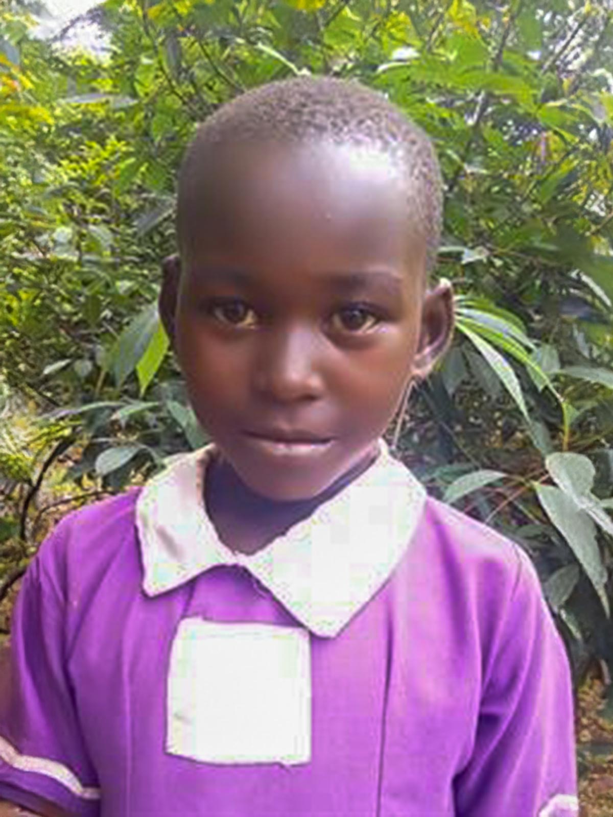 a sponsored girl in uganda wears a purple, white collared dress