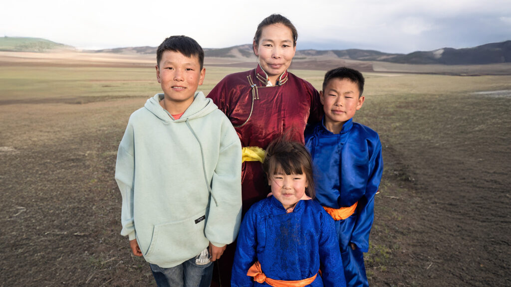 A family standing together outside in rural Mongolia