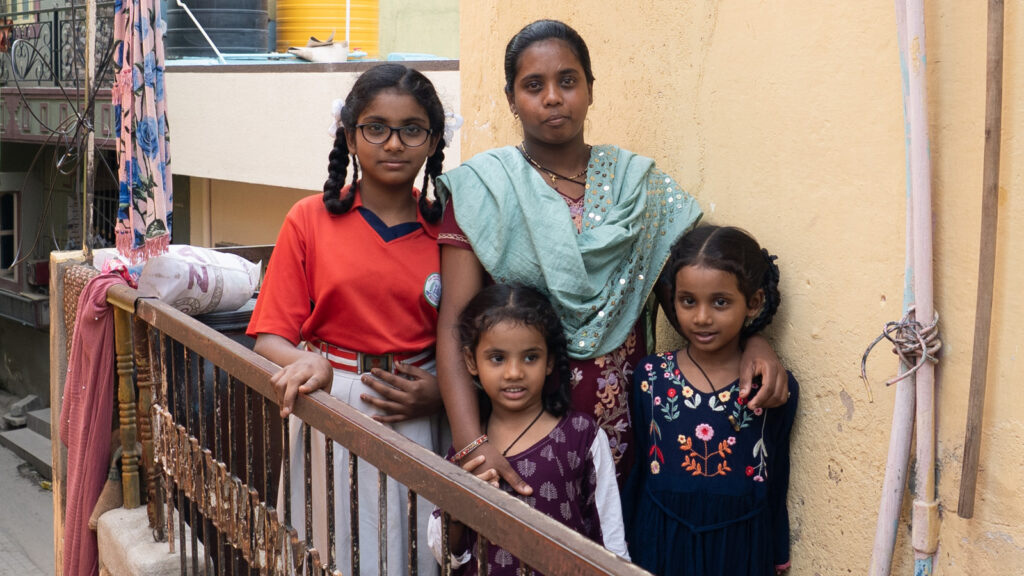 A mom in India standing outside with her three little girls