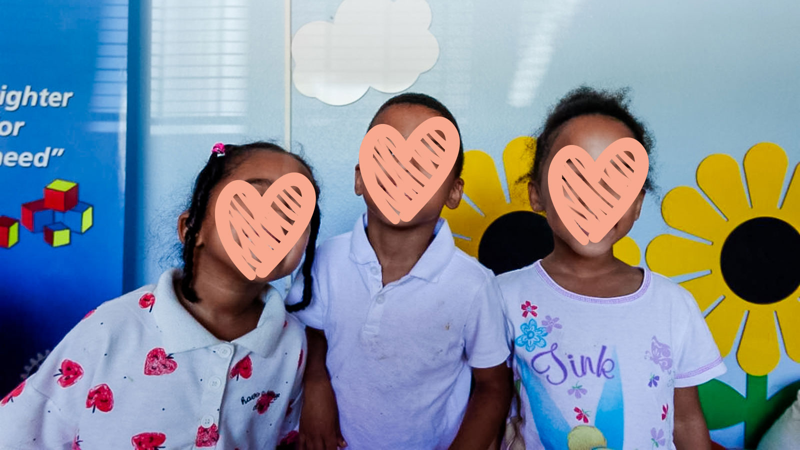 these three siblings, standing in front of a sunflower mural, are waiting for an adoptive family