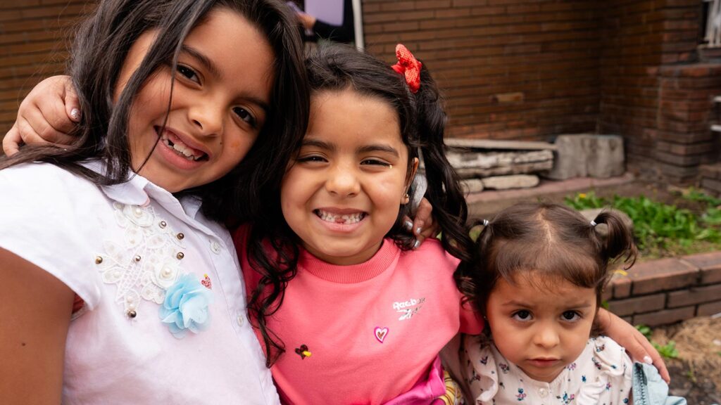 three sisters smile in colombia with their new coats and shoes, thanks to holt donors