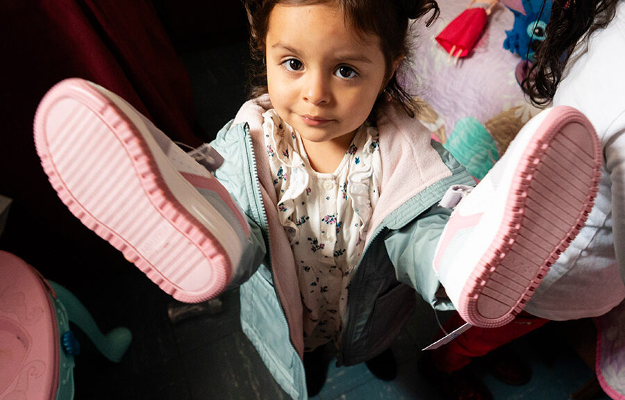 a girl in Colombia shows off her new pair of shoes, thanks to holt donors!