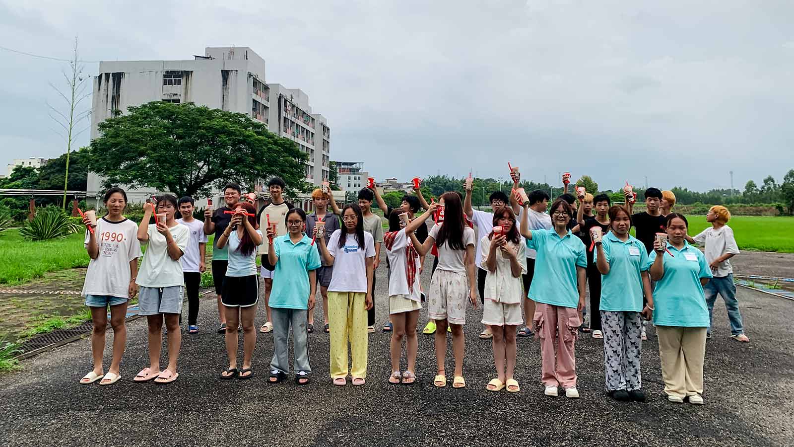 a group of young adults in the Technical School Student Program hold up boba tea during a fun outing