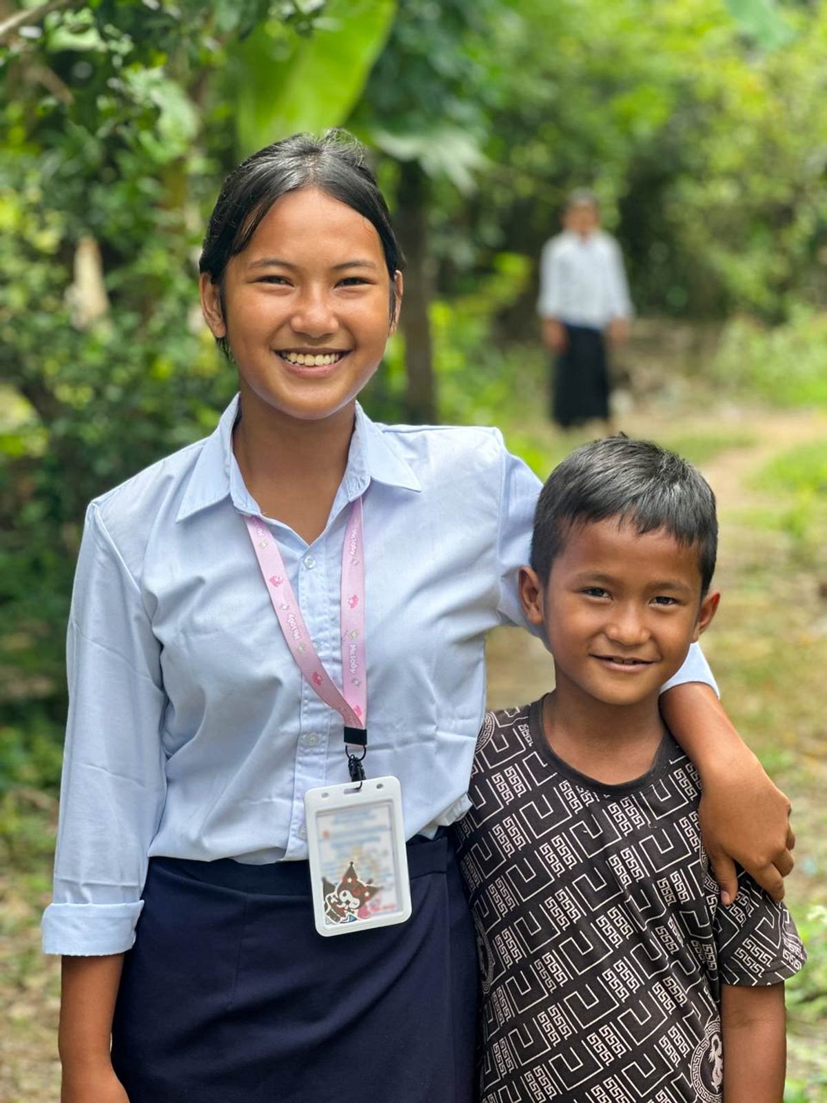 two sponsored siblings embrace each other and smile in Cambodia