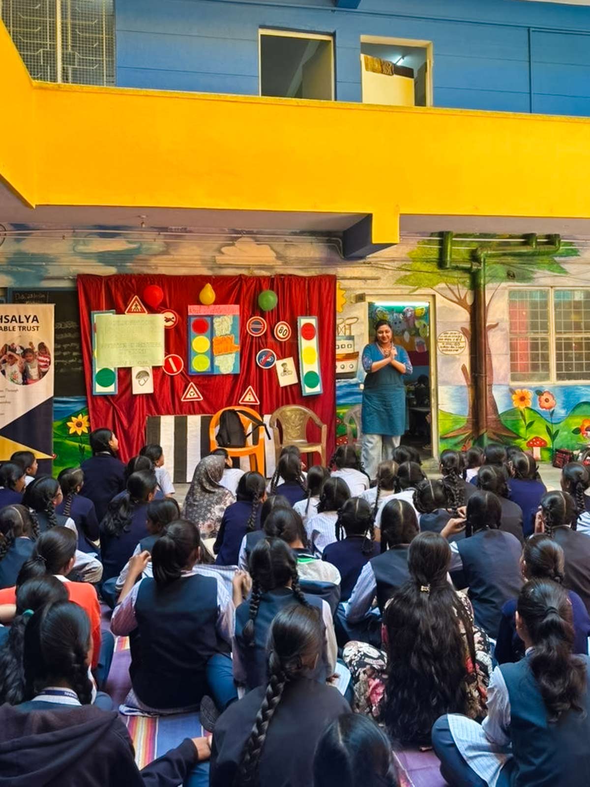 a teacher gives a talk about child rights to a crowd of girls at school in India.