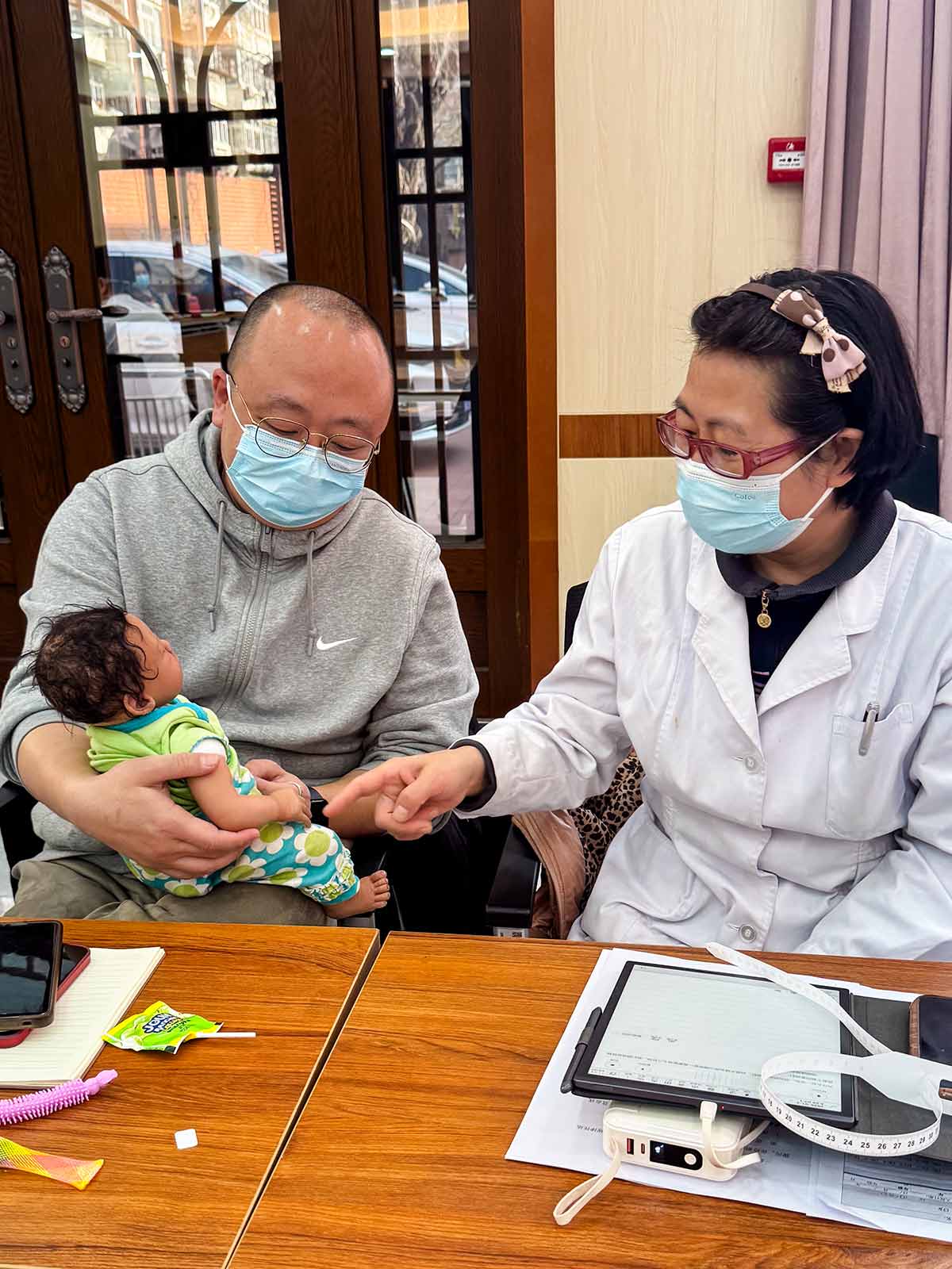 two caregivers practice feeding techniques with a doll in China