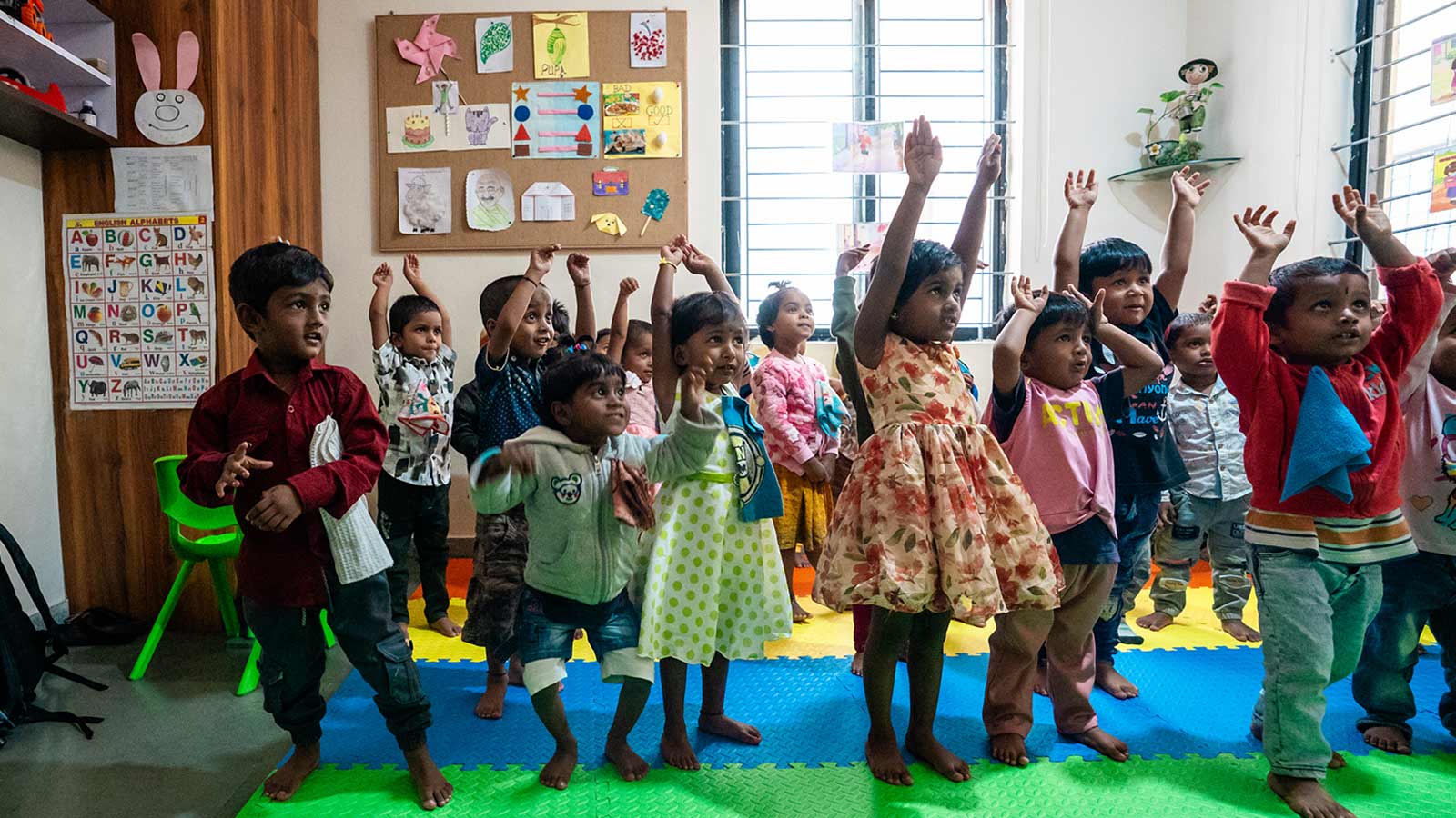 a group of three year olds recite a song and dance in their migrant daycare classroom