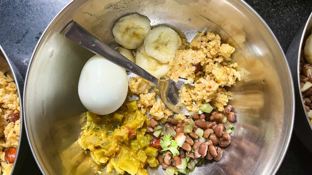 a vibrant lunch at a migrant daycare with lentils and veggies, a boiled egg, curry and a banana