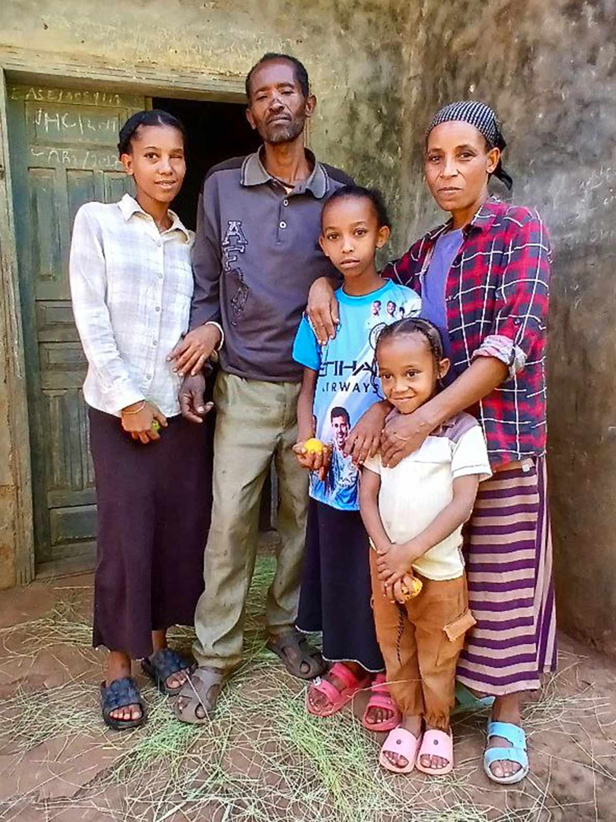 a family of five in Ethiopia stands in front of their home after they received a Gift of Hope