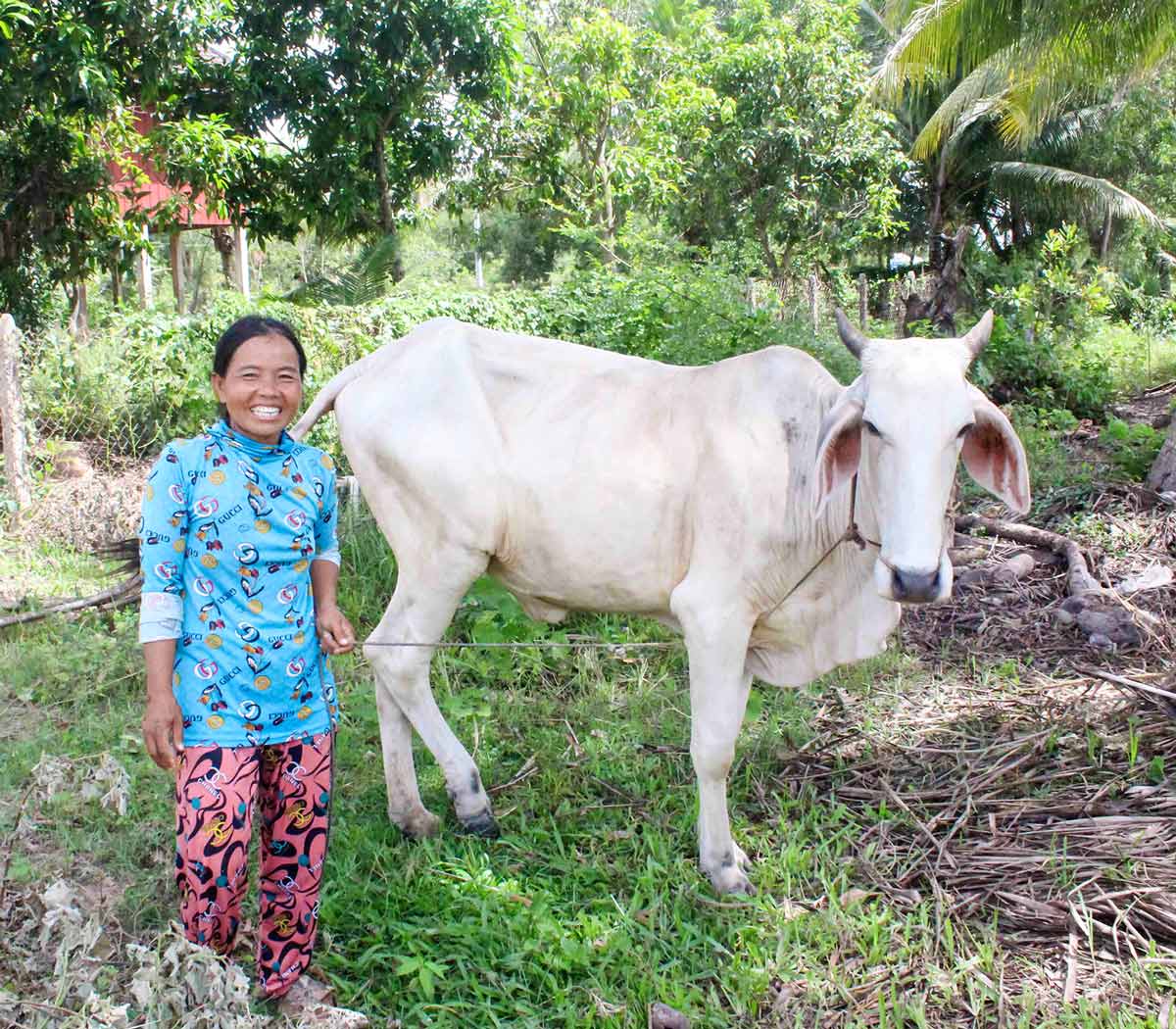 a mom stands next to her cow, which she purchased herself