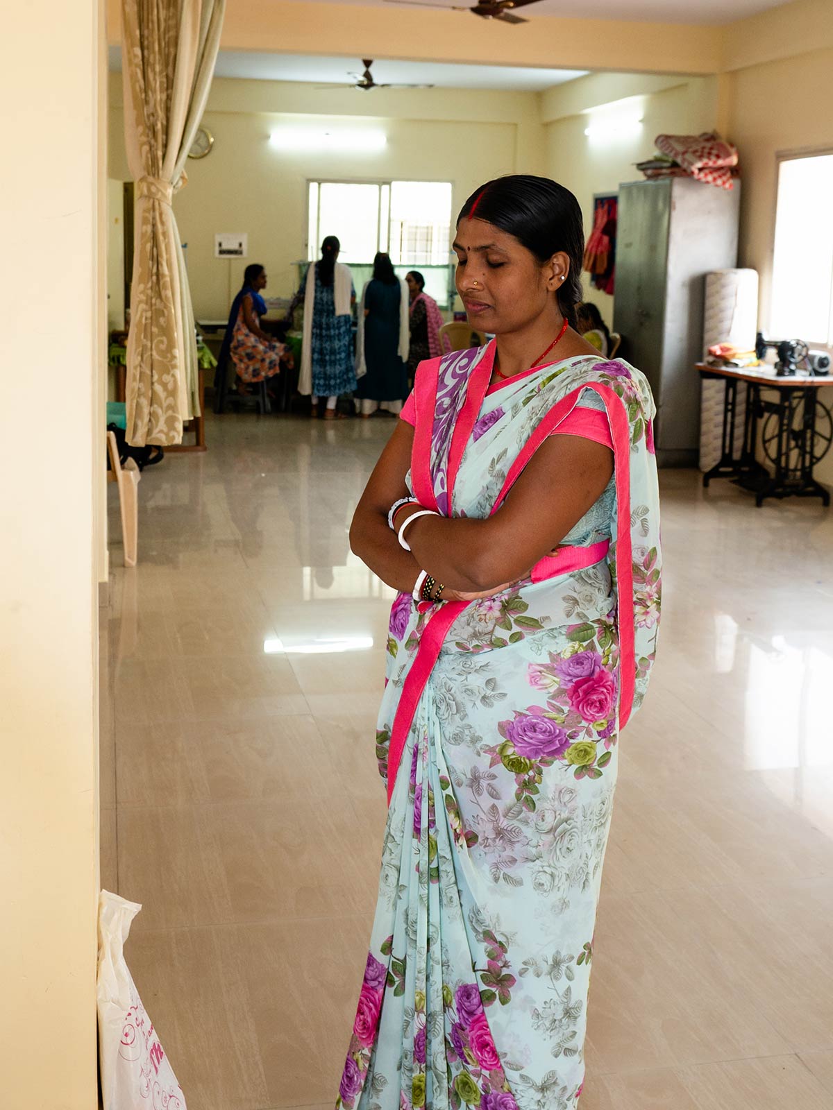 a woman in a floral sari stands in a women's center in Southern India