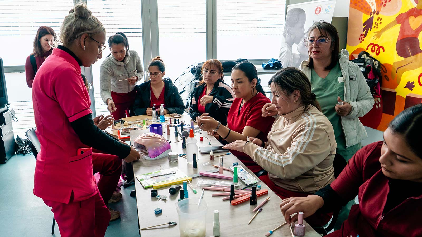 In Colombia, women gather around a table to practice nail tech skills