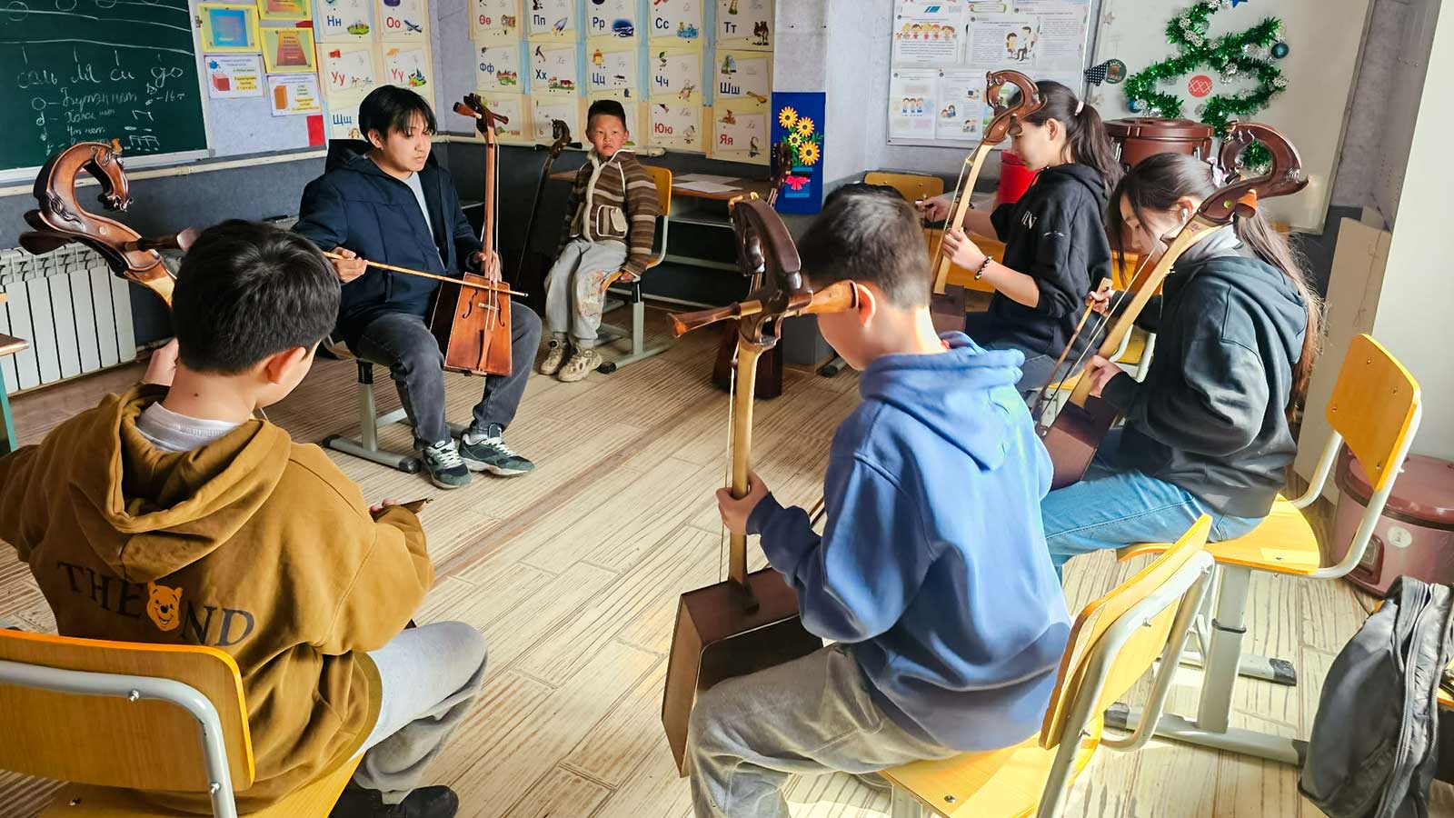 a group of children in Mongolia practice with stringed instruments