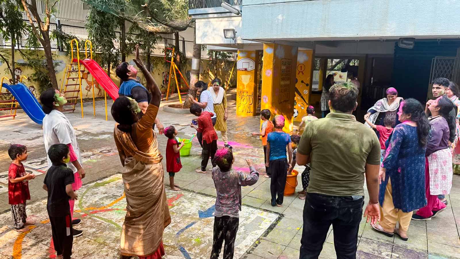children and caregivers at a child center in India celebrate Holi