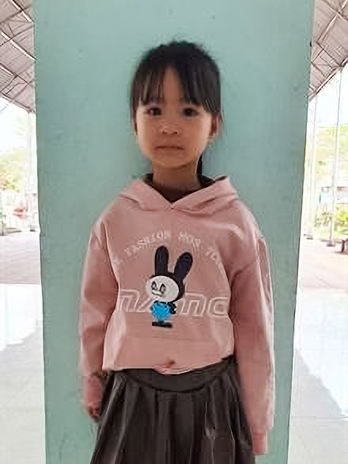 a sponsored girl from vietnam wears a pink sweatshirt