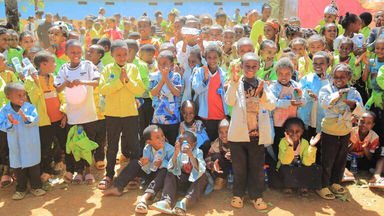 a group of children smile at a celebration in Ethiopia