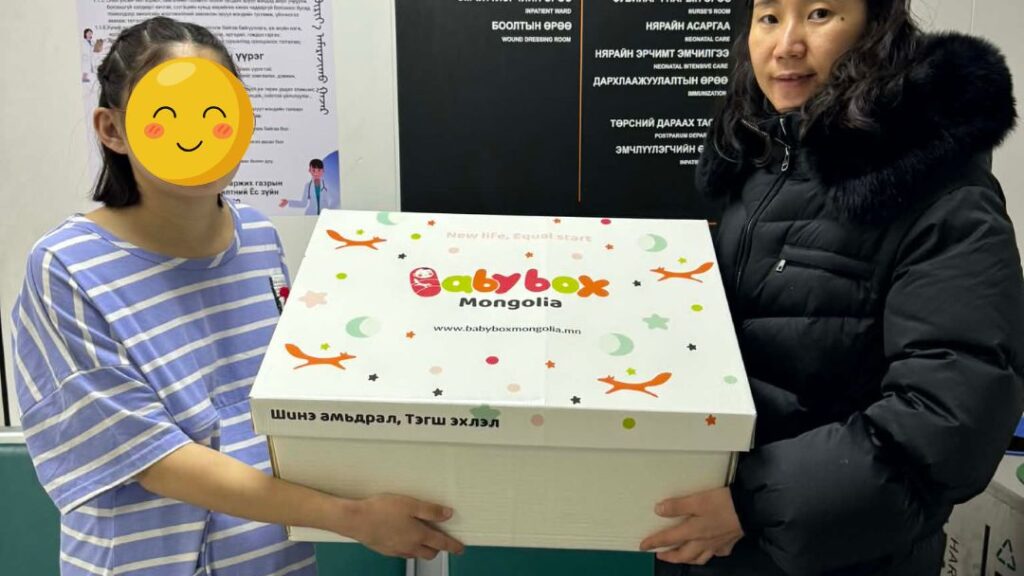 Single mother holds baby box at Princess Center in Mongolia