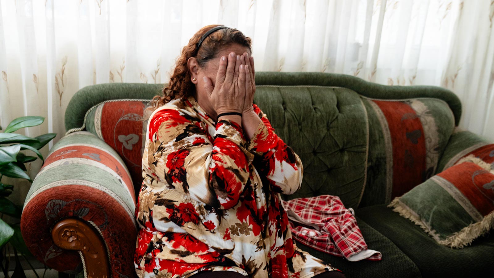 a grandmother tells her story and places her hands over her face