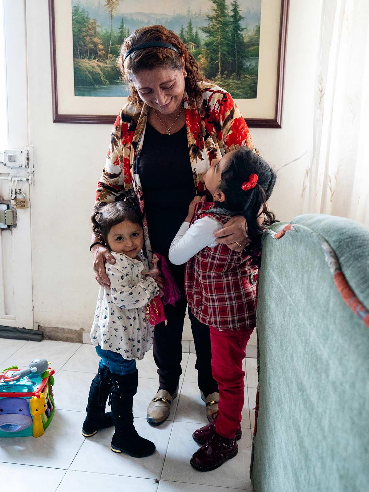 a grandmother hugs her two granddaughters