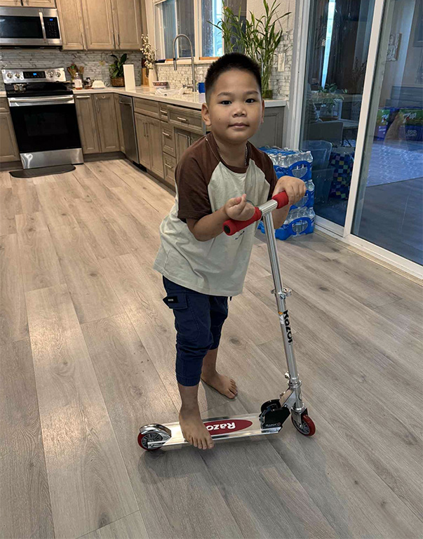 Thien rides a scooter at home