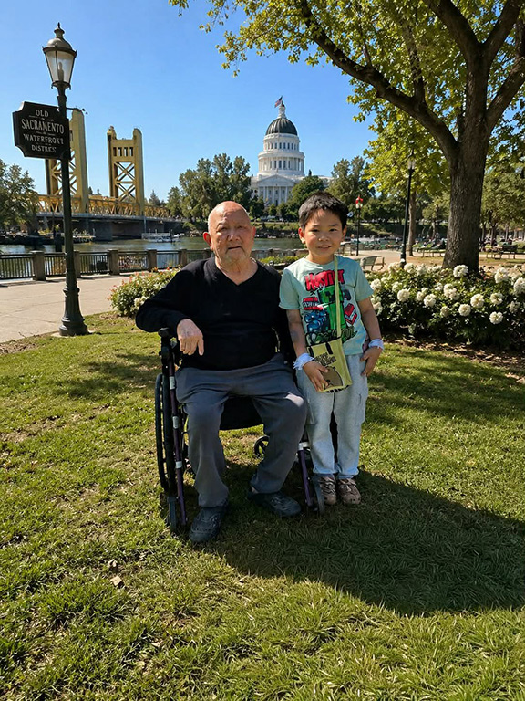 Thien poses with his grandfather, who is in a wheelchair