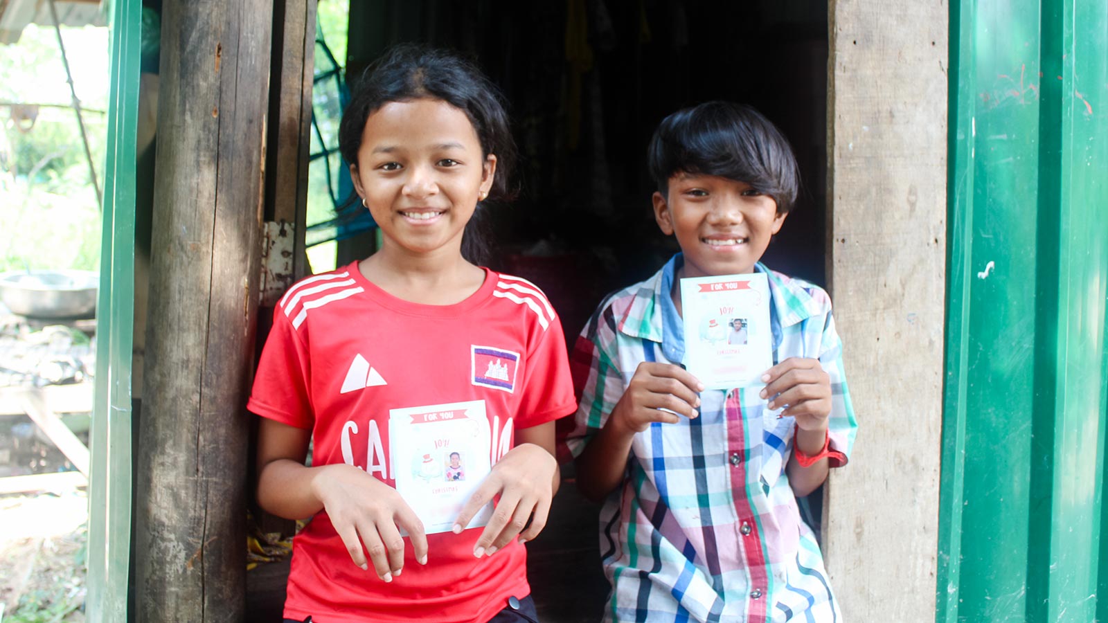 sponsored twins in Cambodia show Christmas cards from their sponsors