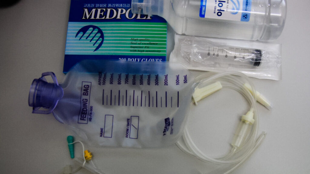 feeding tube supplies — gloves, saline, bag and tube