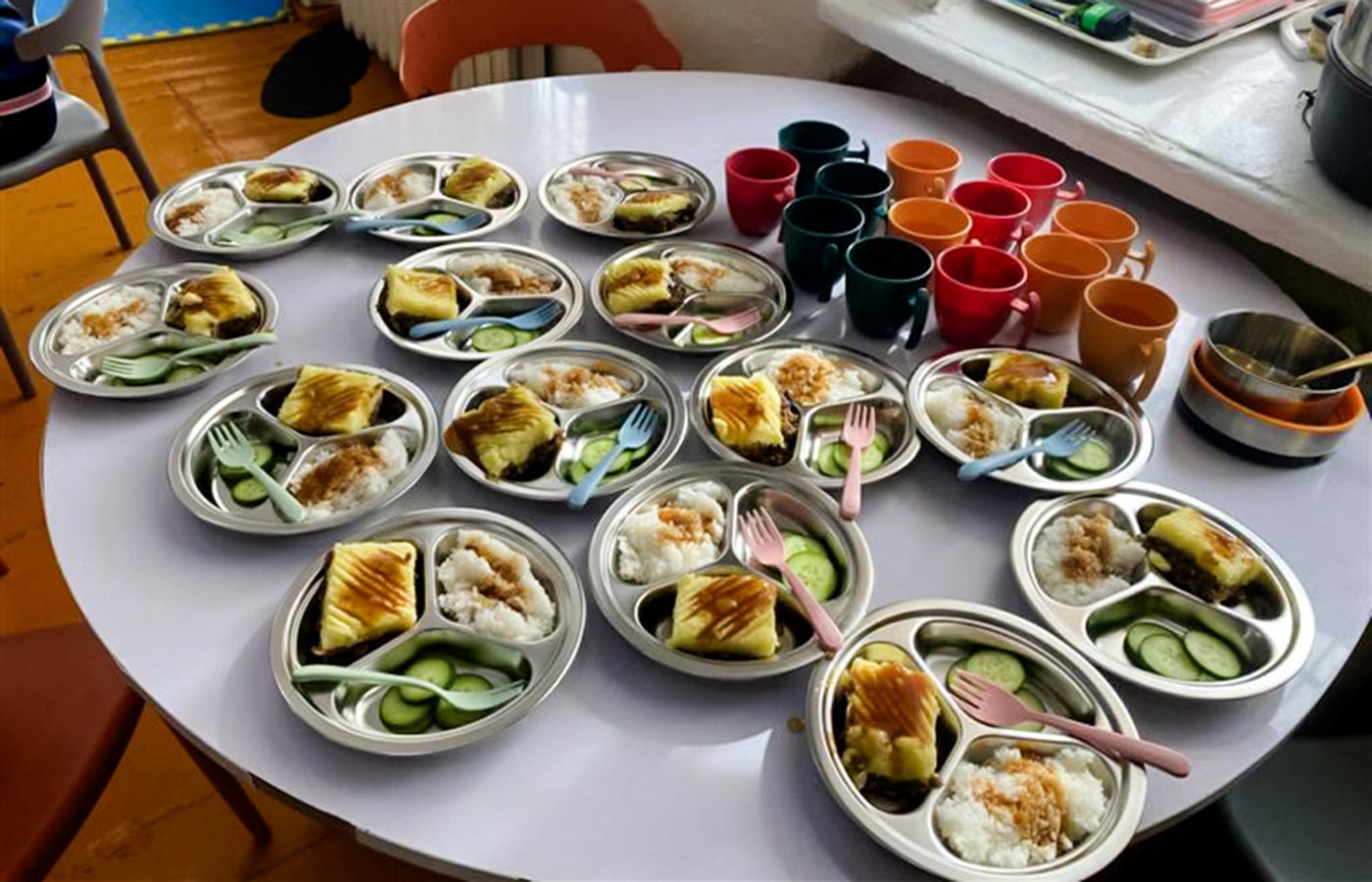 A dozen school lunches — full of colorful, nutritious food — sit on a classroom table in Mongolia