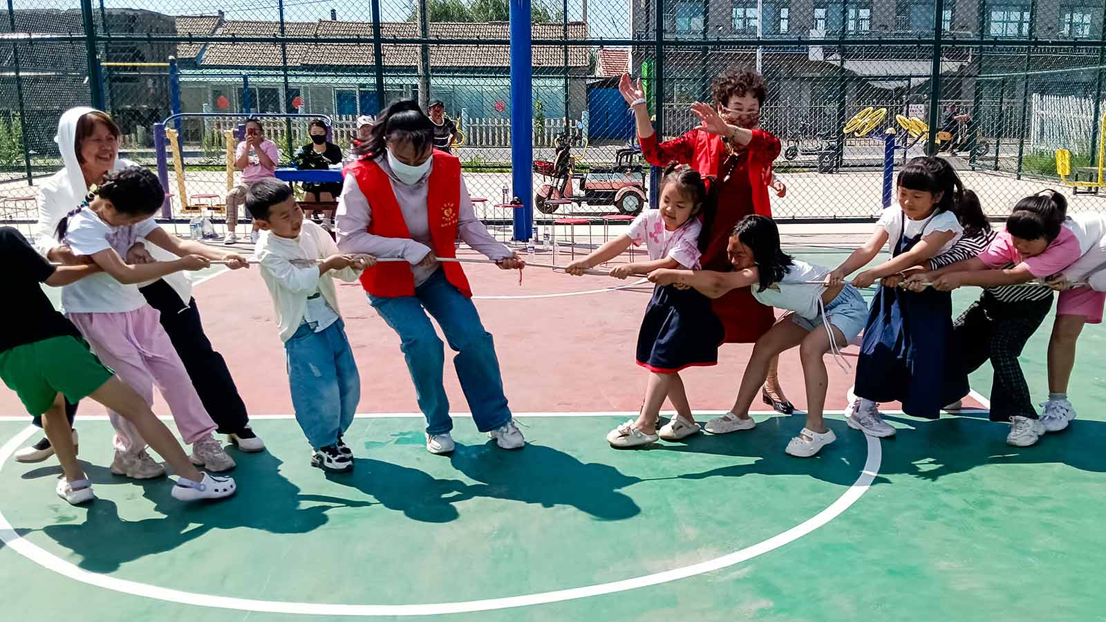 children in China play tug-of-war outside on the basketball court